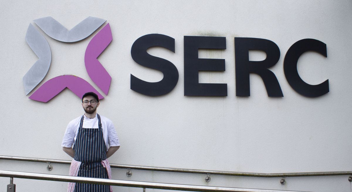 Dylan Murphy pictured outside the Bangor campus with the 'SERC' logo pictured in the background.